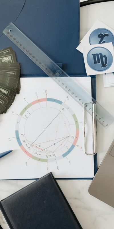 Astrology chart setup with cards, ruler, and symbols on a table.
